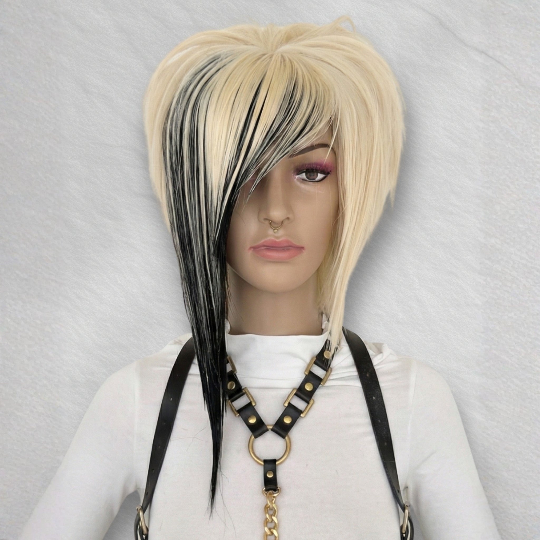 Front view of short emo scene wig with blonde and black streaks, layered asymmetrical bob with side-swept bangs and silk top part, alternative cosplay wig for visual kei, harajuku, gothic and y2k fashion.